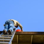 An elderly man climbs a ladder to his roof. Matthews' Painting Company's Stay Off the Ladder service project helps prevent falls and injuries for senior citizens and disabled veterans.