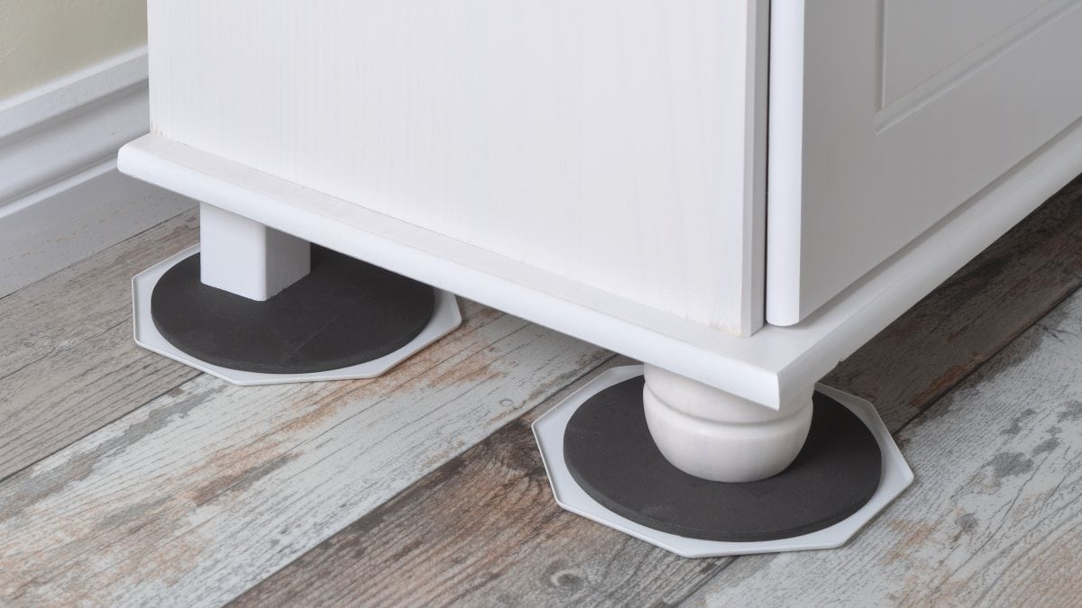 Furniture slider placed under a furniture leg to safely move heavy furniture across flooring without scratches or damage.