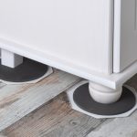 Furniture slider placed under a furniture leg to safely move heavy furniture across flooring without scratches or damage.