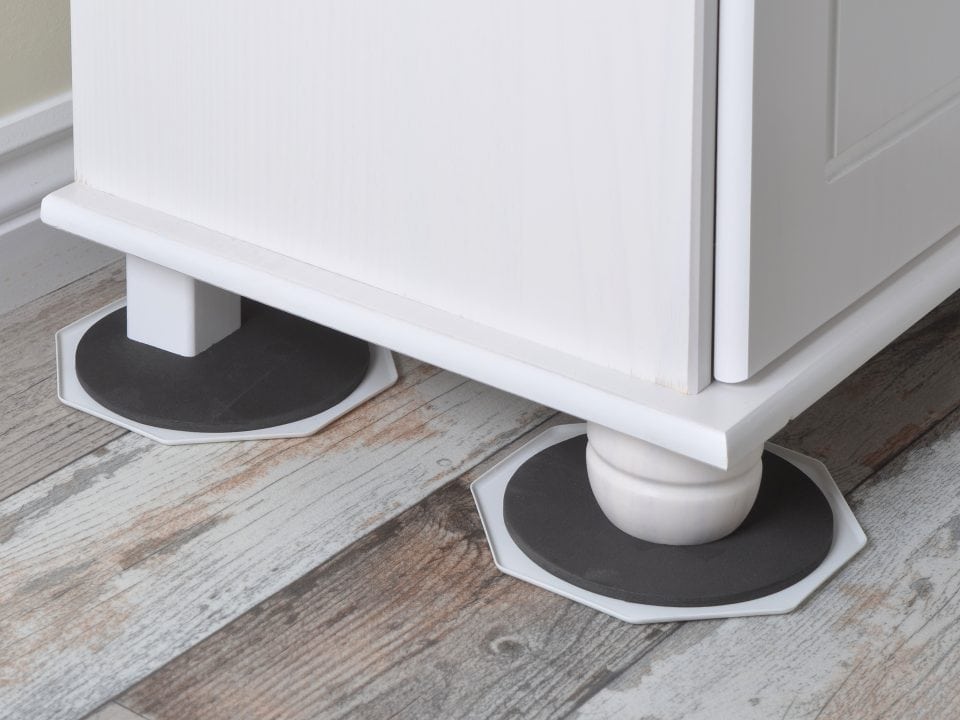 Furniture slider placed under a furniture leg to safely move heavy furniture across flooring without scratches or damage.