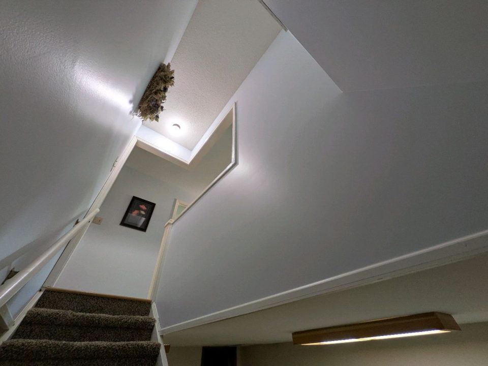 Before and after wallpaper removal and interior painting on a stairwell in Rochester, Indiana