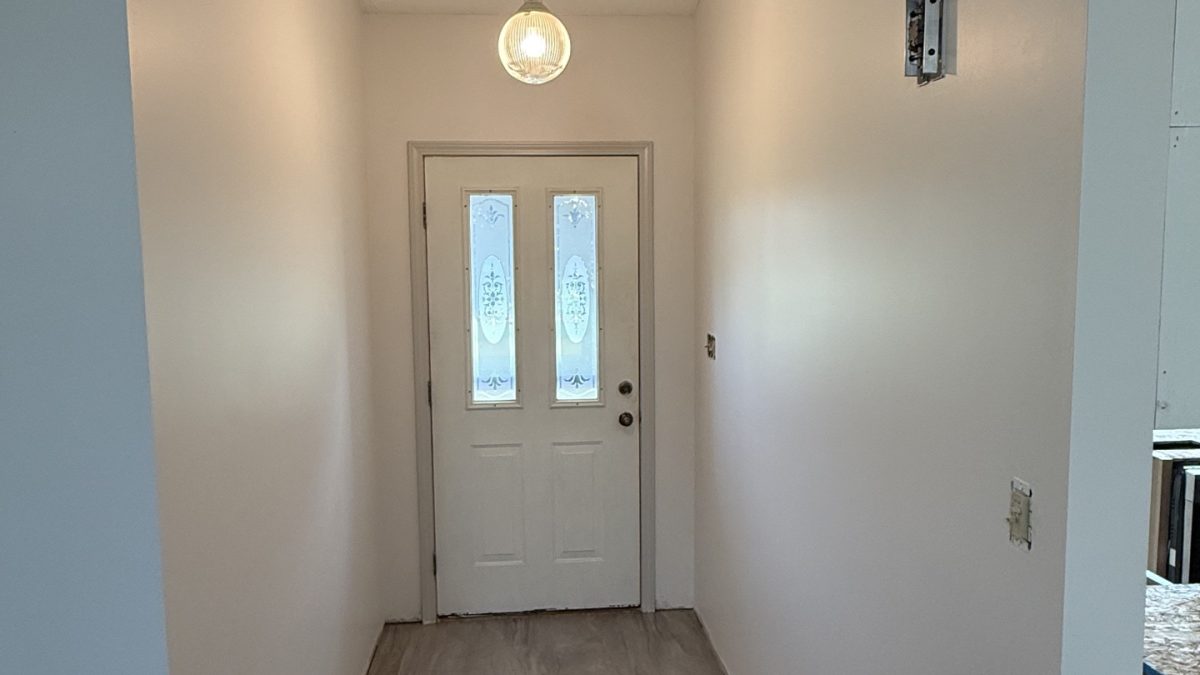 Freshly painted hallway with light neutral walls and white doors in an Albion, Indiana, home.