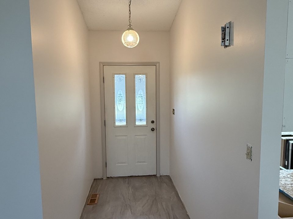 Freshly painted hallway with light neutral walls and white doors in an Albion, Indiana, home.